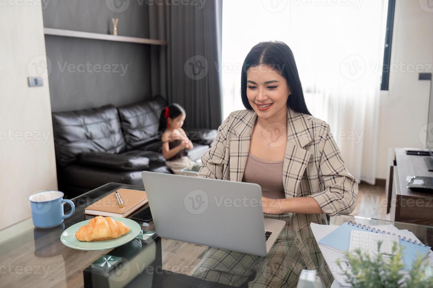 attività commerciale donna o mamma Lavorando con sua poco figlia a un' il computer portatile. libero professionista, opera a partire dal casa foto