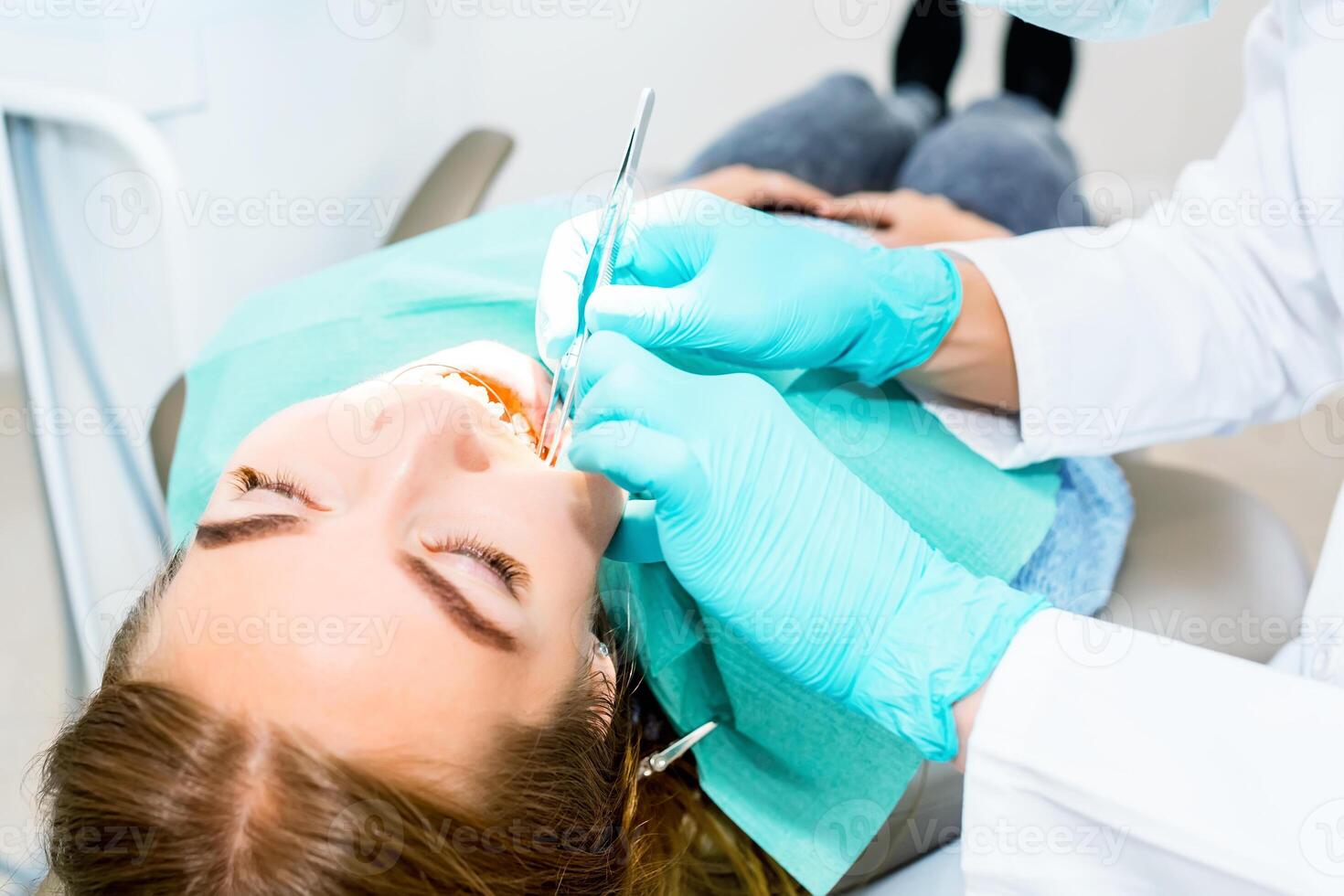 femmina dentista controllo su paziente denti con bretelle a dentale clinica ufficio. medicinale, odontoiatria concetto. dentale attrezzatura. vicino su. foto