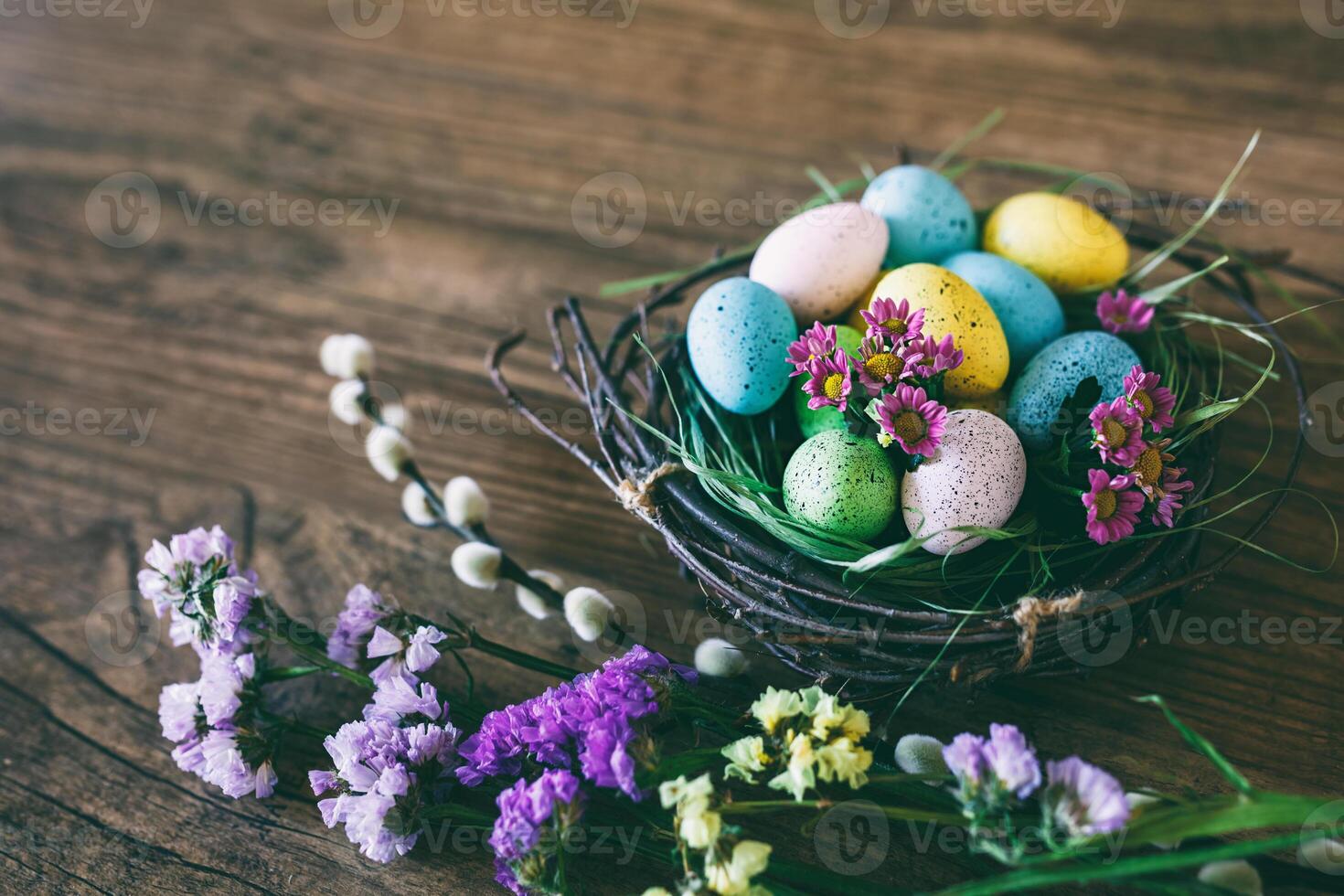 Pasqua sfondo. luminosa colorato uova nel nido con primavera fiori al di sopra di di legno buio sfondo. selettivo messa a fuoco con copia spazio. foto