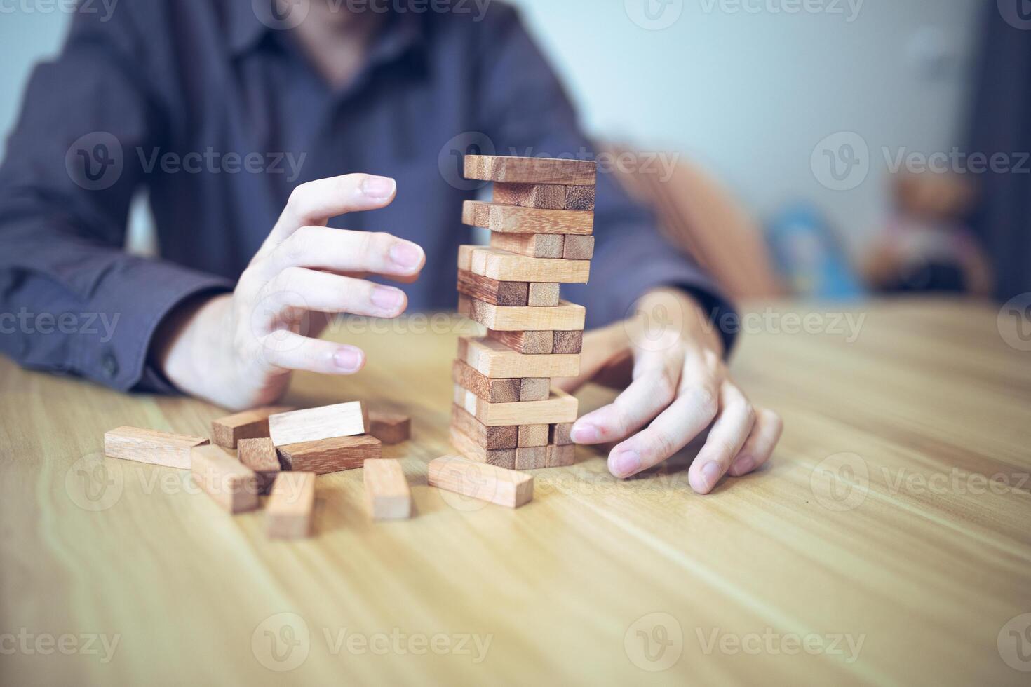 attività commerciale strategia concetto con mani giocando un' di legno bloccare Torre gioco, simboleggiante rischio e stabilità. pianificazione rischio gestione foto