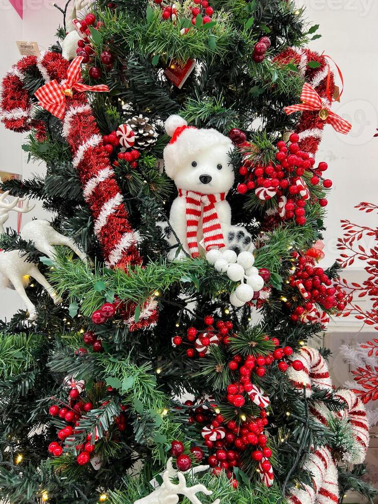 Natale albero decorato con orsacchiotto orso, ghirlande e giocattoli foto