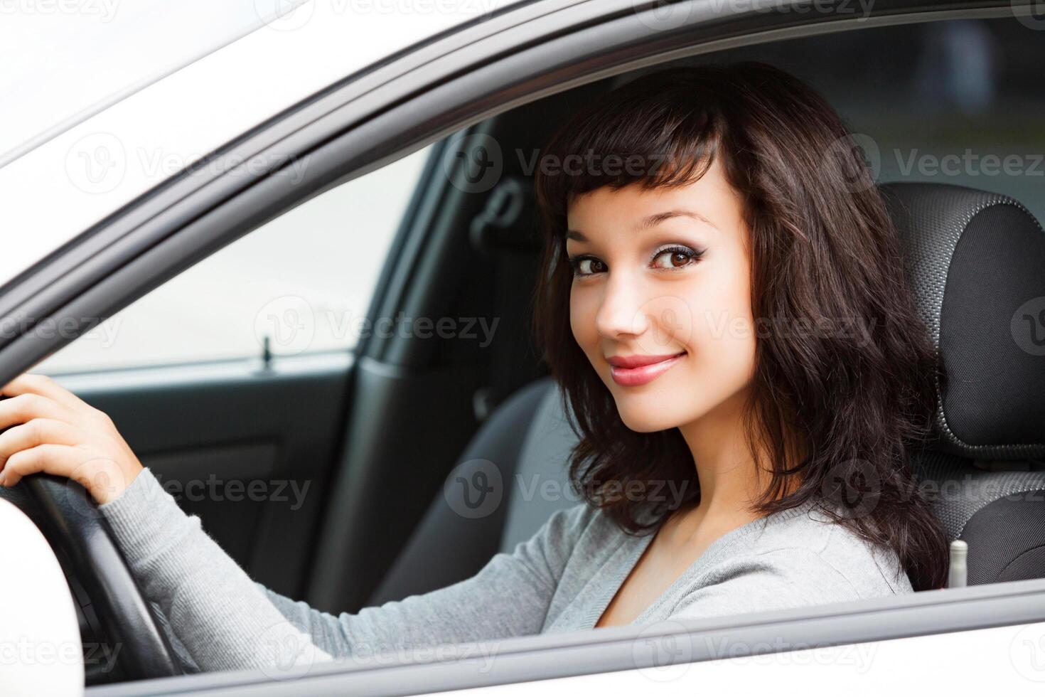 bella donna autista sorridente per voi a partire dal il bianca auto foto
