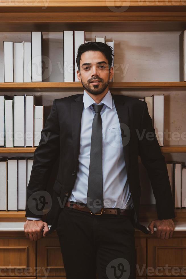 giovane uomo d'affari bello del Medio Oriente che indossa giacca e cravatta in piedi in ufficio. concetto di business foto