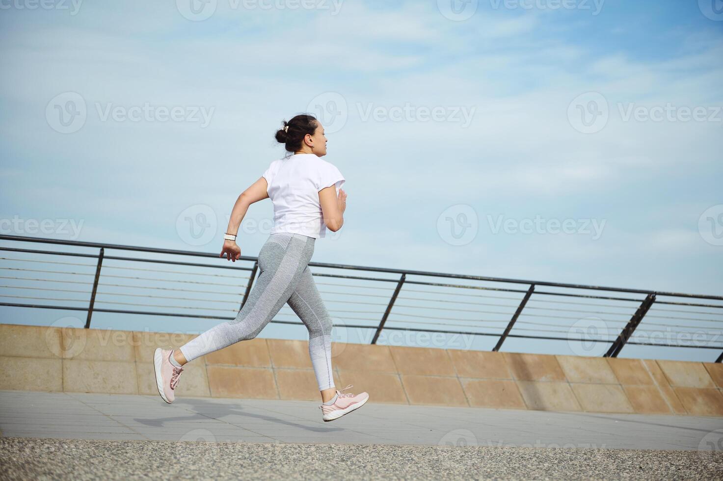 Visualizza a partire dal il indietro per un' sportiva, corridore jogger atleta fare cardio allenamento, in esecuzione all'aperto su il città ponte foto