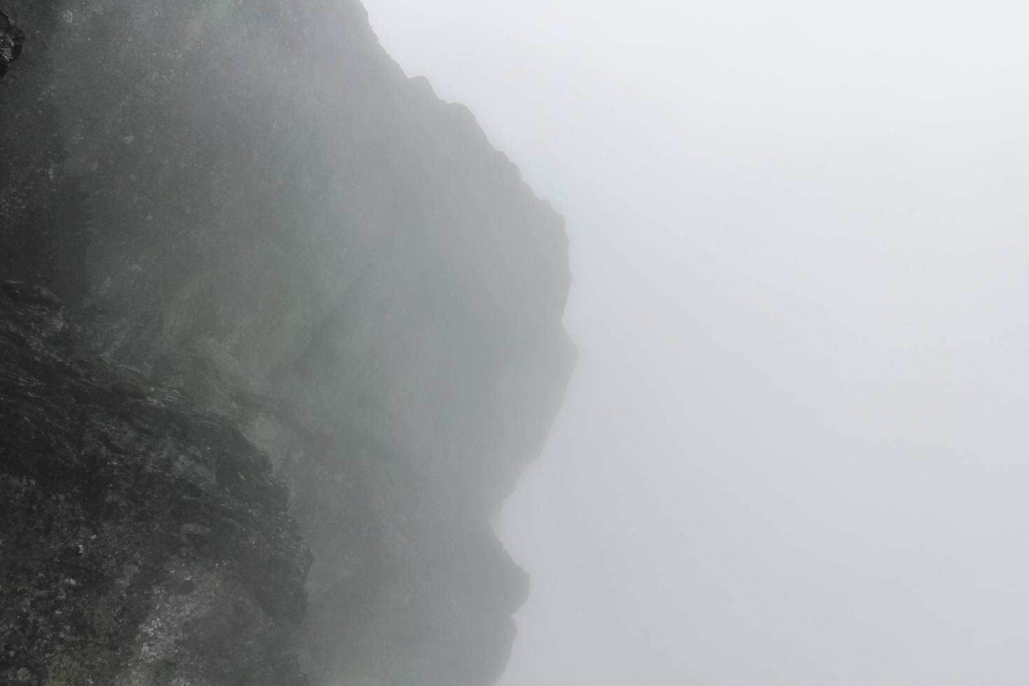 nebbia, nuvole, rocce e scogliere sulla montagna veslehodn veslehorn, norvegia. foto