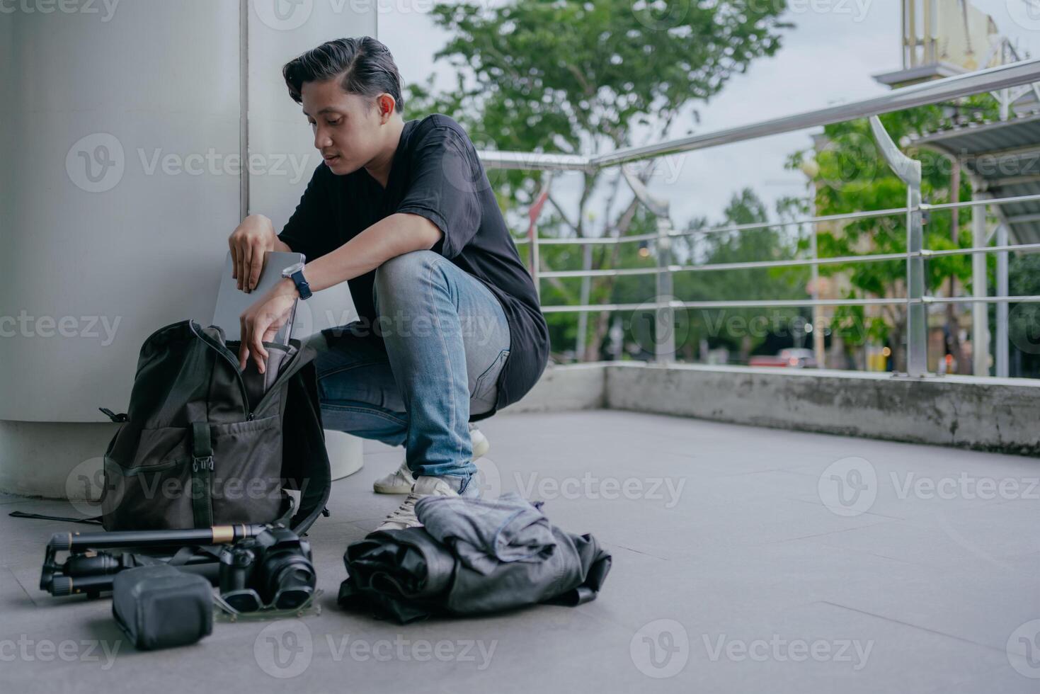 indonesiano maschio fotografo è Imballaggio bagaglio e ottenere pronto per viaggio. vacanza viaggio concetto. foto