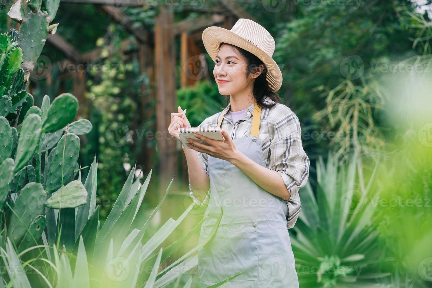 giovane donna asiatica si prende cura del giardino foto