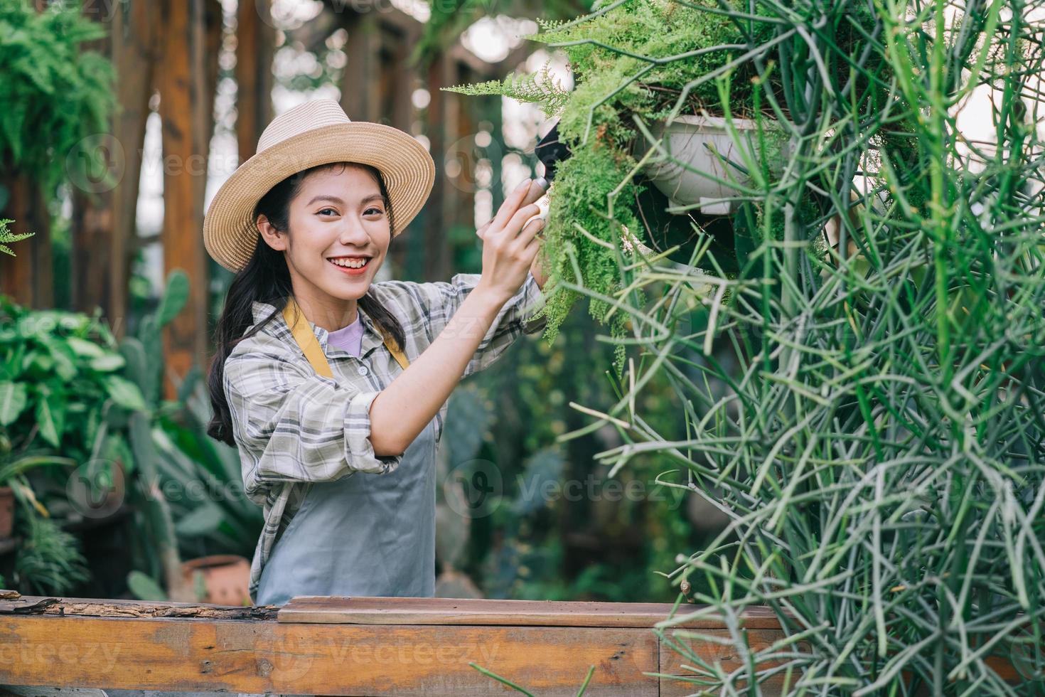 giovane donna asiatica si prende cura del giardino foto