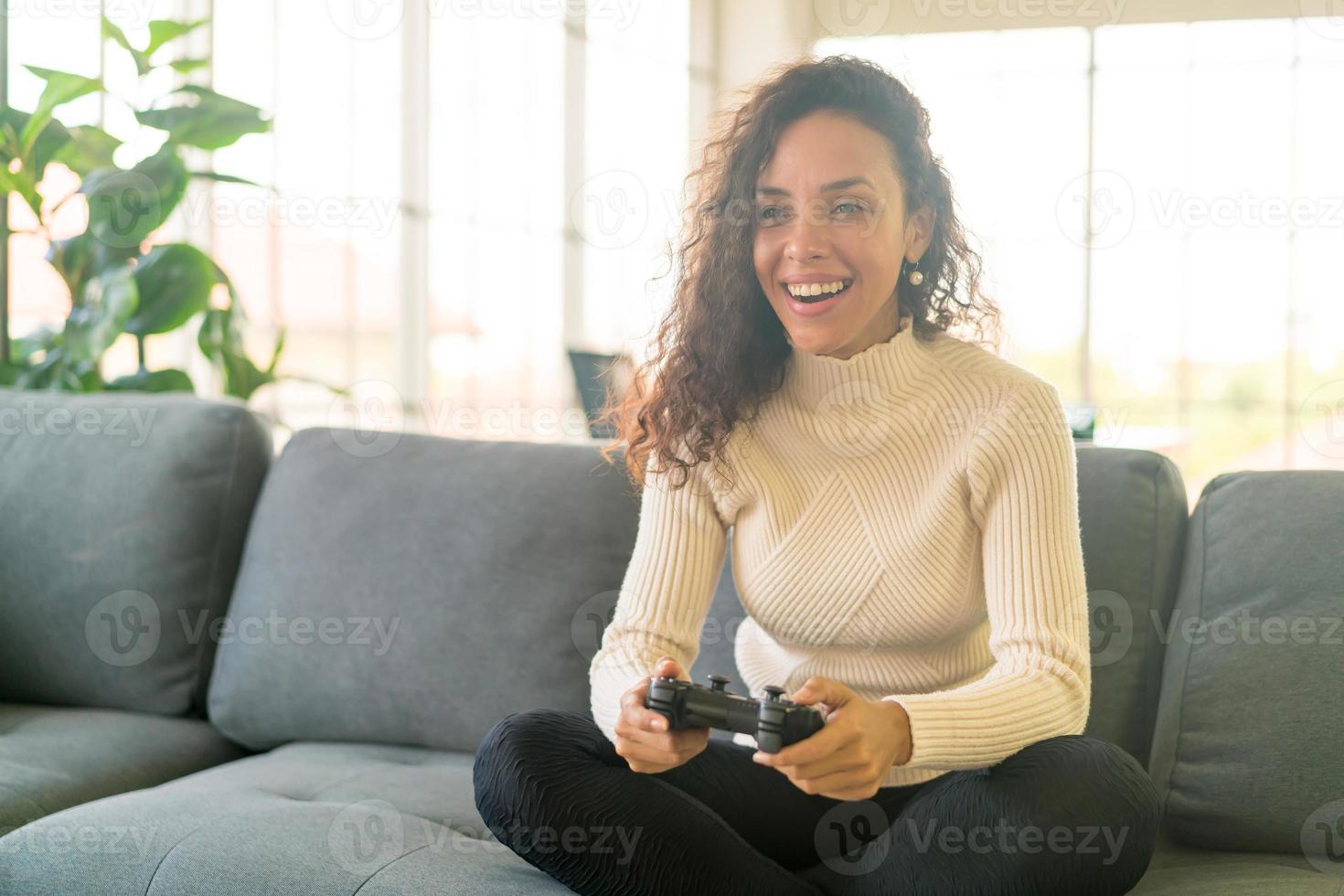 donna latina che gioca ai videogiochi con le mani che tengono il joystick foto