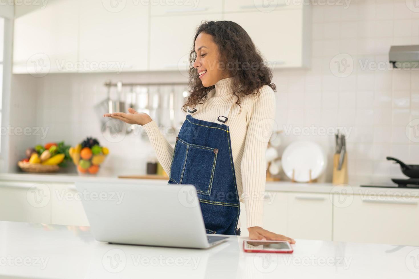 donna latina che gira video e cucina in cucina foto