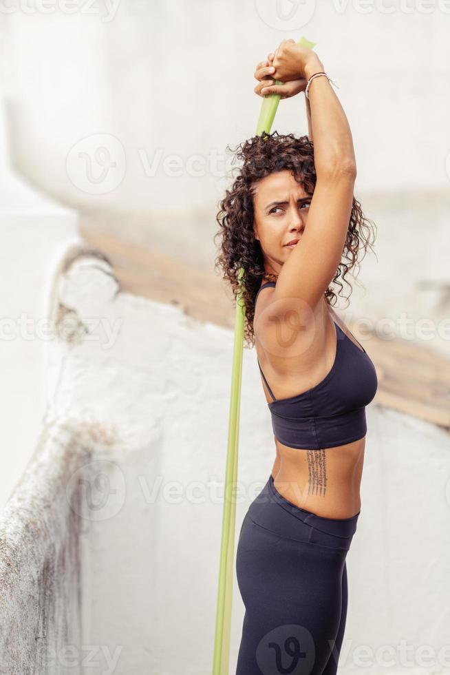 donna di mezza età con un corpo in forma che si allena sulla terrazza di casa sua foto