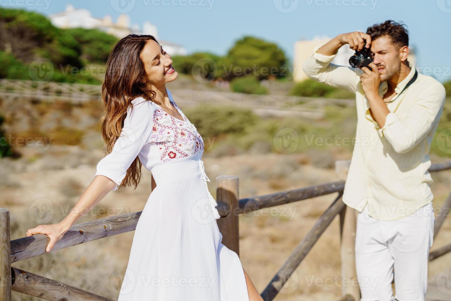 uomo che fotografa la sua ragazza durante un viaggio d'amore. foto