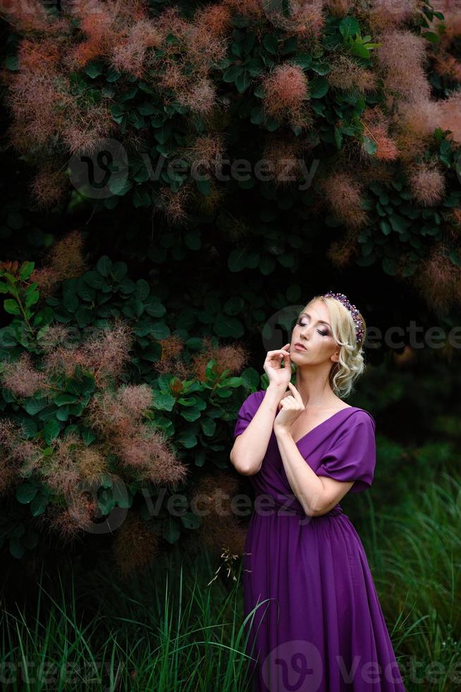 ragazza modella bionda in un abito lilla con un bouquet foto