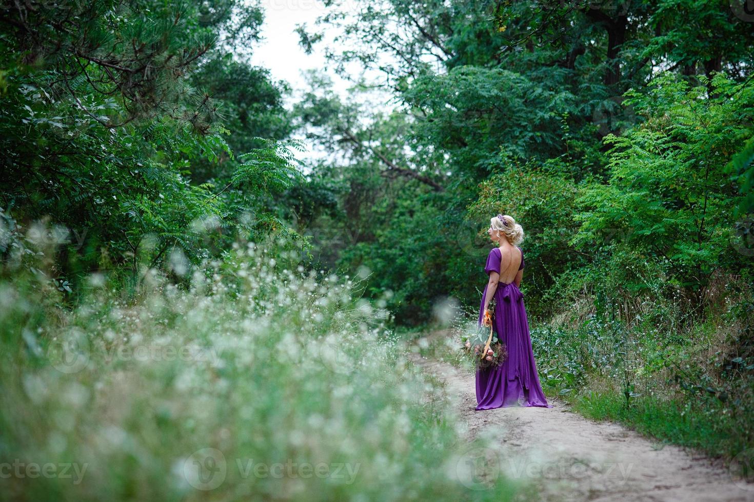 ragazza modella bionda in un abito lilla con un bouquet foto