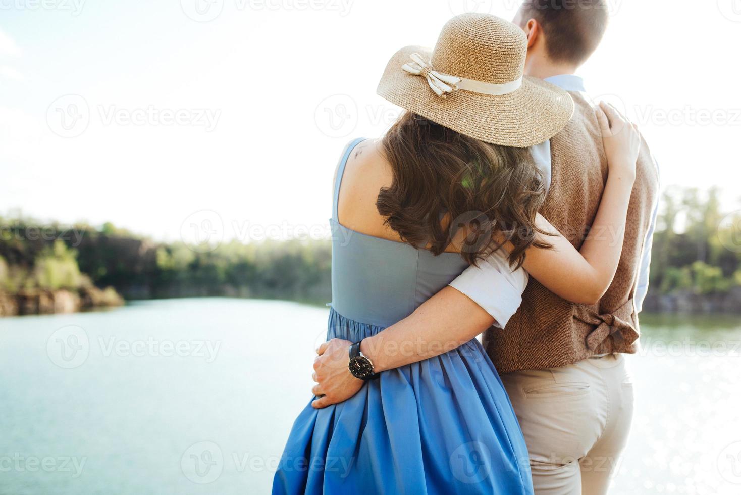 una giovane coppia un ragazzo e una ragazza stanno camminando vicino a un lago di montagna circondato foto