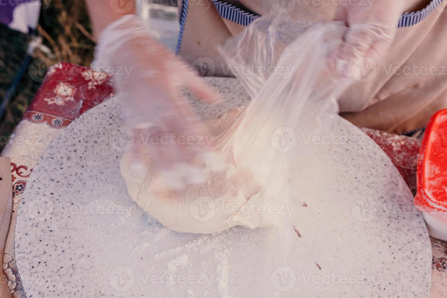 donna di mani fabbricazione qutab o chebureki con un' rotolamento perno e tritato carne cipolla nel Impasto per culinario concetti relazionato per azerbaigiano, tatar e greco cucina, come bene come empanadas nel latino America. foto