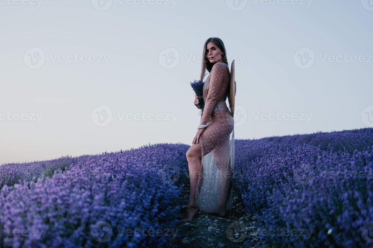 donna lavanda campo. contento spensierato donna nel beige vestito e cappello con grande orlo odorare un' fioritura lavanda su tramonto. Perfetto per ispirazione e caldo concetti nel viaggio e voglia di viaggiare. vicino su foto