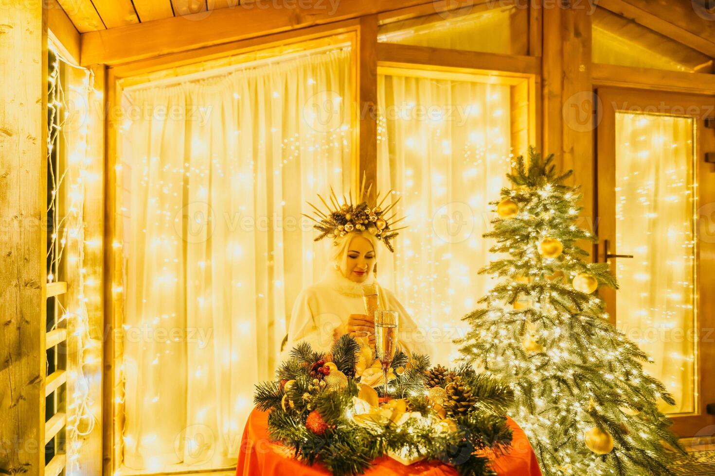 contento sorridente donna nel un' bianca vestito Tenere un' Champagne bicchiere nel davanti di un' Natale albero. foto