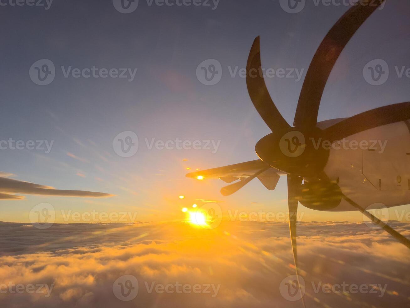 rotante elica di un aereo volante nel il raggi di il ambientazione sole foto
