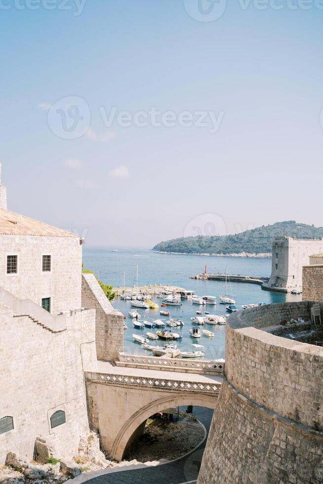 Visualizza a partire dal dietro a il fortezza muri per il molo con ormeggiato Barche. dubrovnik, Croazia foto