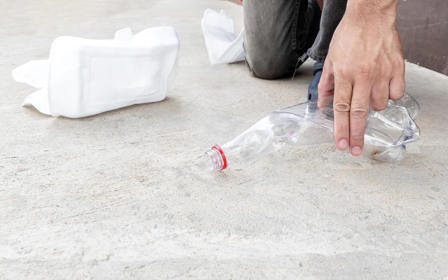 uomo mantenere compressa plastica bottiglia su il pavimento foto
