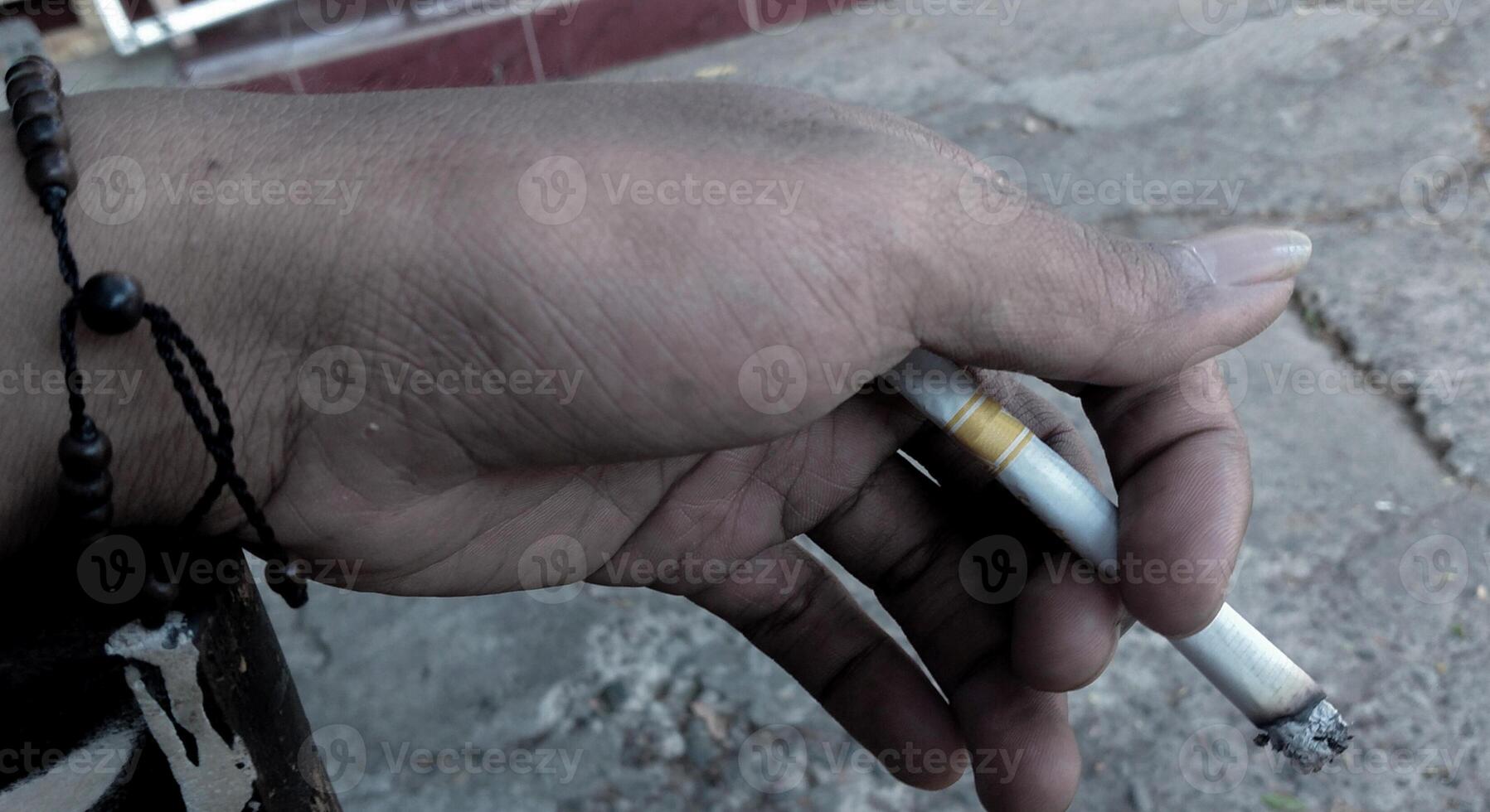 vicino su di un' sigaretta nel il mani di un vecchio uomo. fotografia arte concetto foto