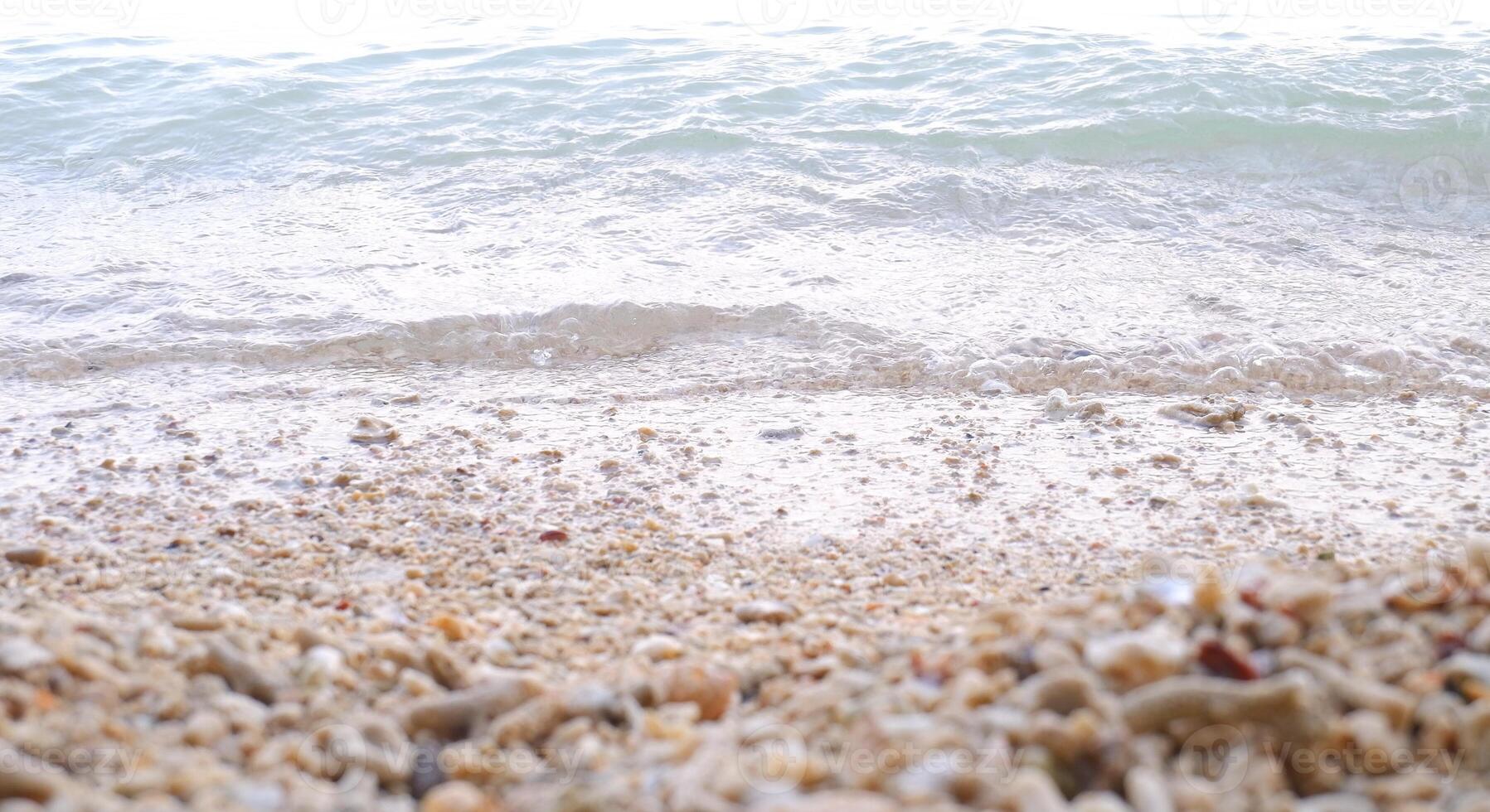 spiaggia sabbia e mare onda su bianca sfondo, morbido messa a fuoco. foto