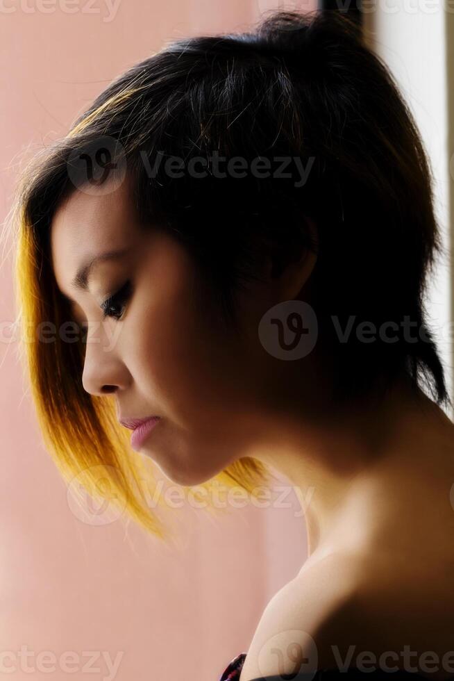 profilo ritratto asiatico americano donna finestra leggero foto