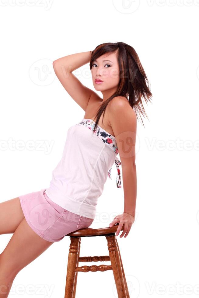 giovane asiatico americano donna seduta su sgabello foto