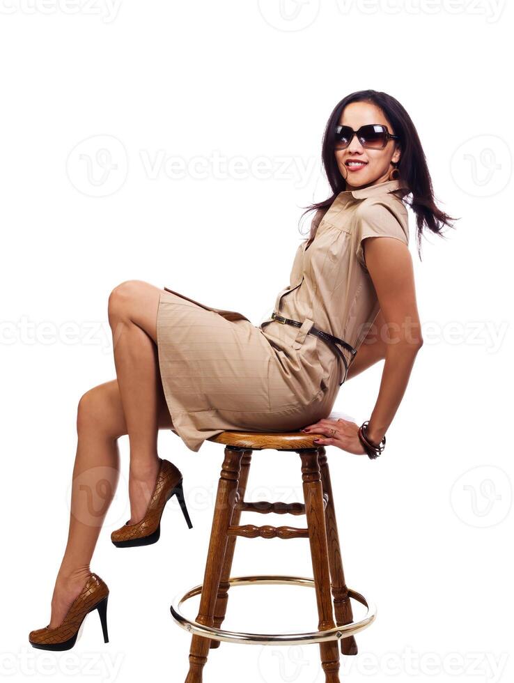 ispanico donna nel Marrone vestito seduta su di legno sgabello foto