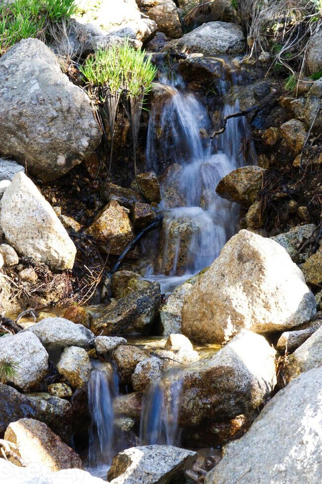 piccolo ruscello a cascata al di sopra di rocce lungo esposizione foto