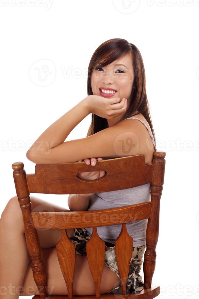 adolescente asiatico ragazza seduta su sedia sorridente foto