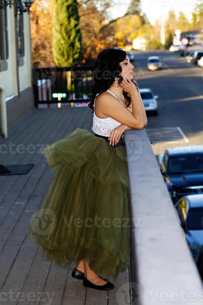 attraente latina donna in piedi su balcone guardare su foto