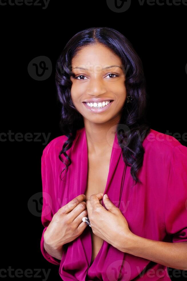 sorridente africano americano donna in piedi contro nero sfondo foto
