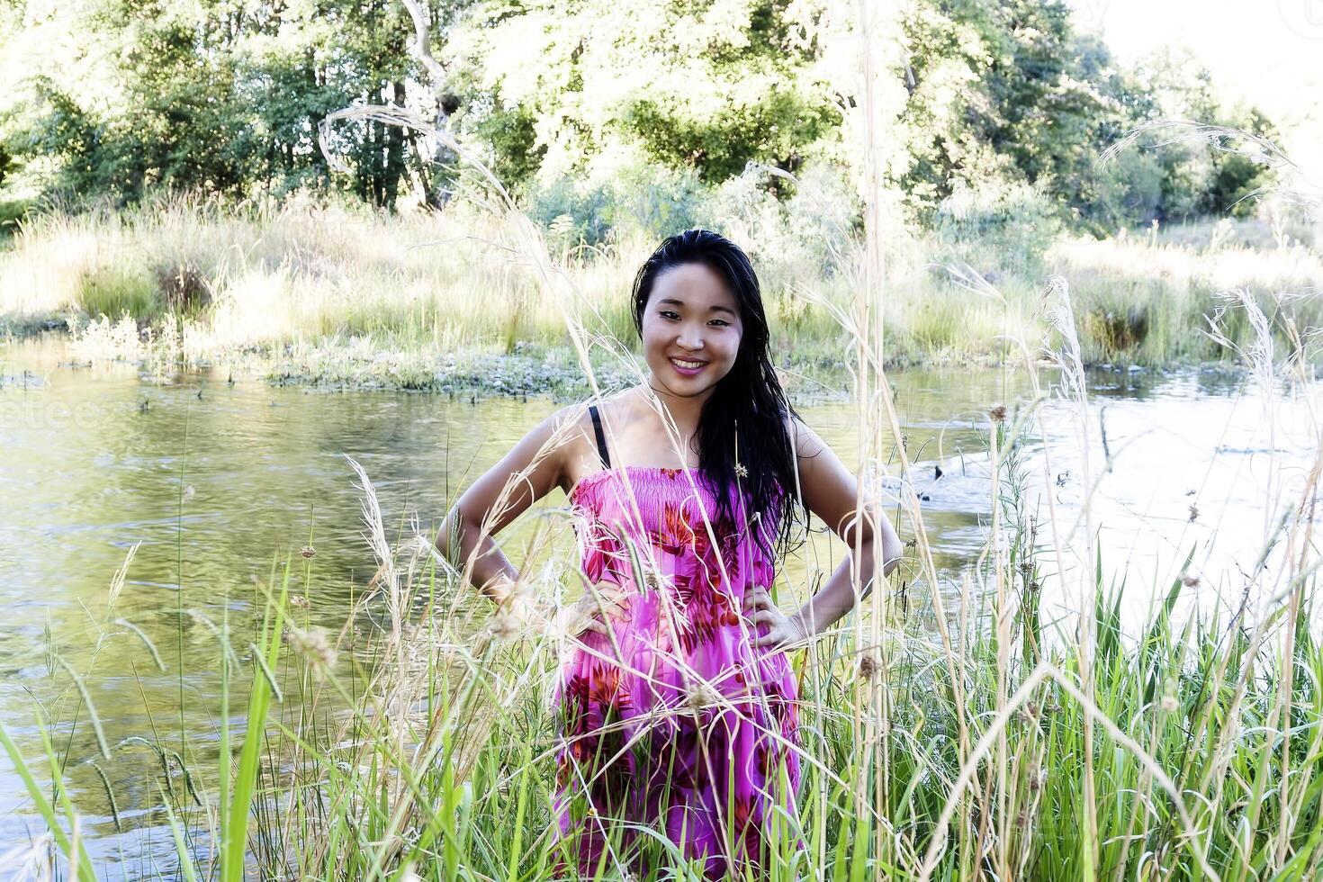 giapponese americano donna a fiume sorridente nel floreale vestito foto