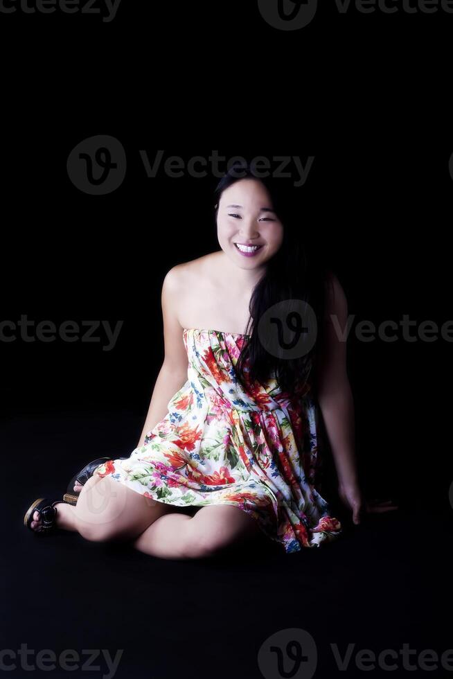 sorridente attraente giapponese americano donna seduta nel vestito foto