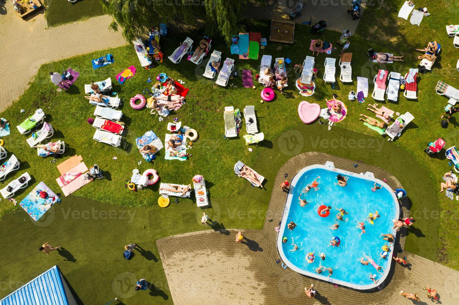 superiore Visualizza di un all'aperto posto per persone per rilassare dove Là è un' nuoto piscina e un' lotto di sole letti foto
