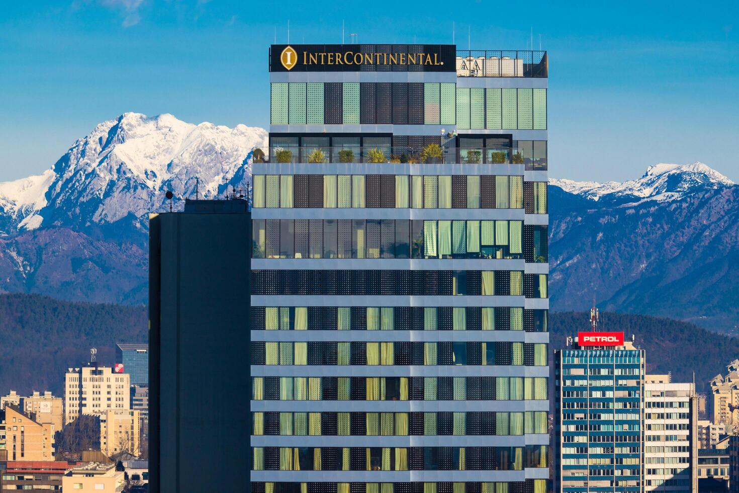 Lubiana, slovenia - dicembre 23, 2023. il intercontinentale Hotel edificio vicino su con il nevoso Alpi nel il sfondo foto