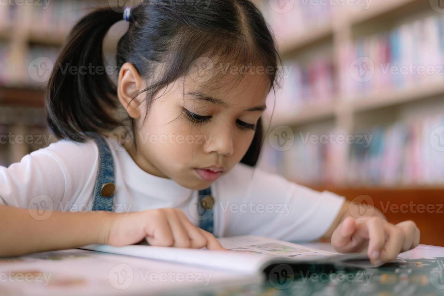 un' giovane ragazza è lettura un' libro nel un' biblioteca foto