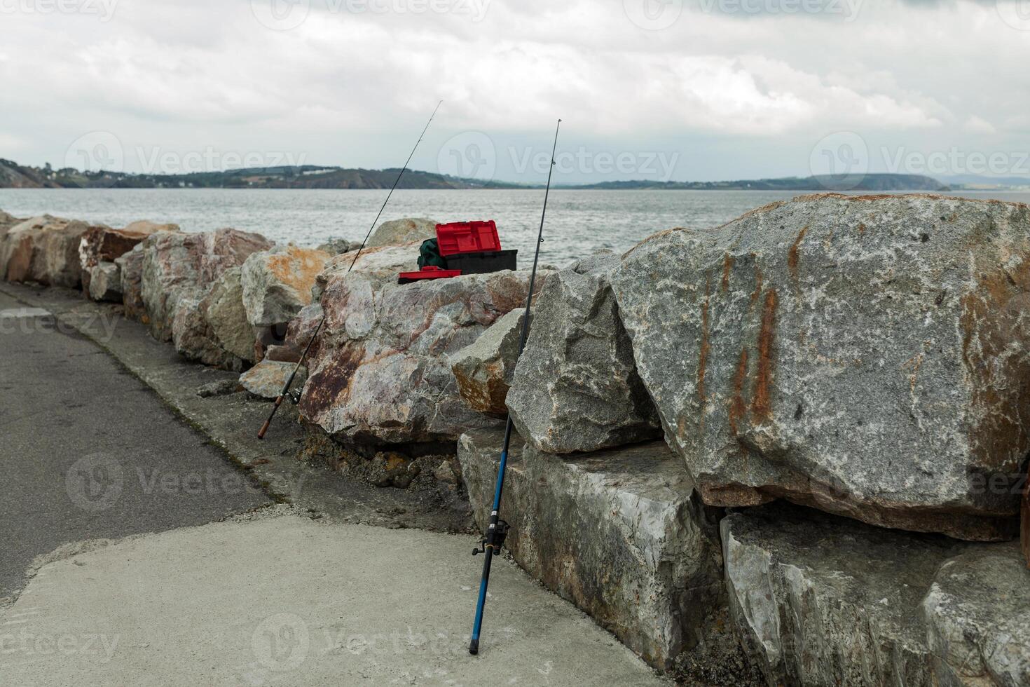 Due pesca canne attaccare su di pietre, su il spiaggia nel morgat Francia 29 Maggio 2018 foto