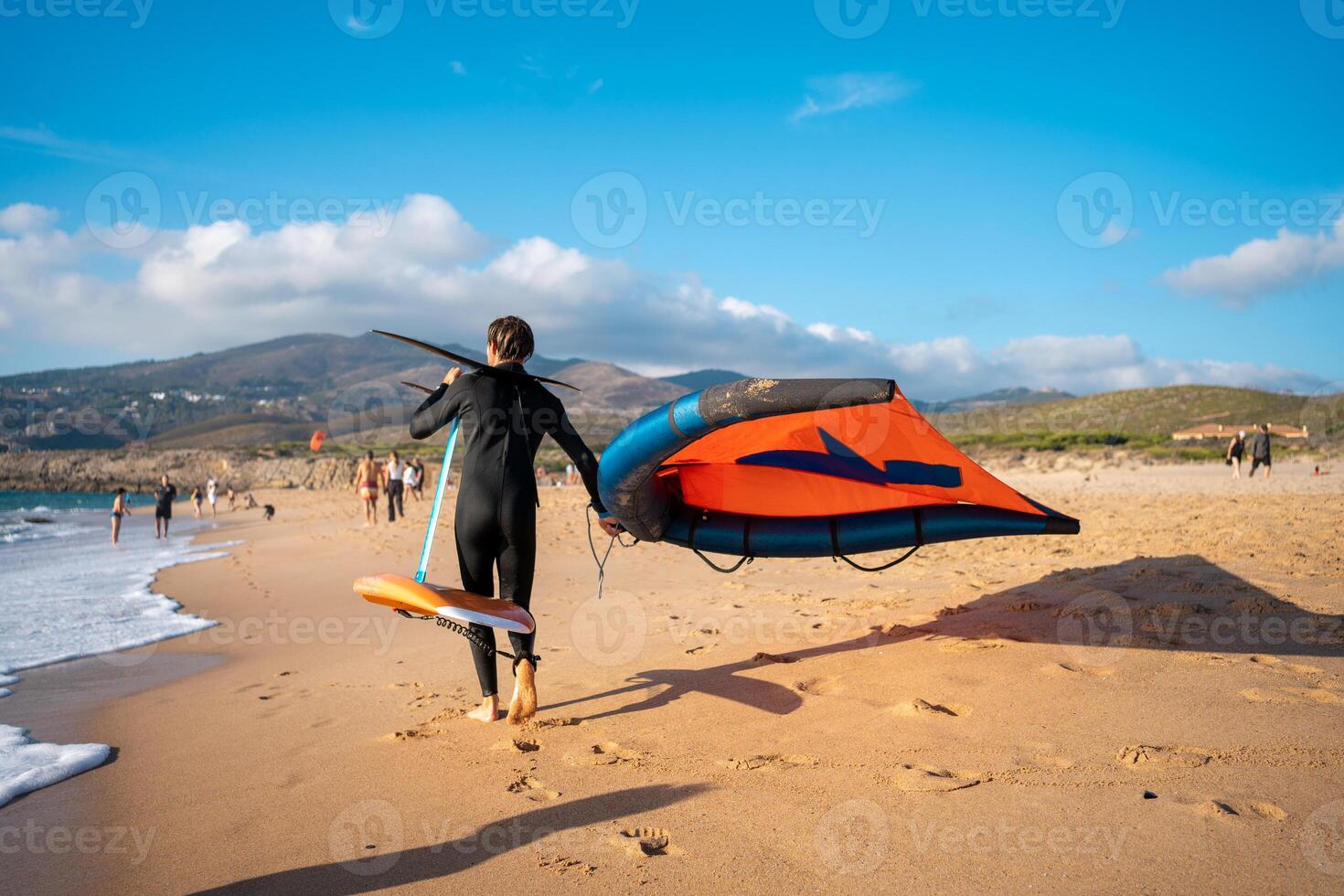 uomo con aquilone aliscafo attrezzatura a piedi sabbioso spiaggia foto