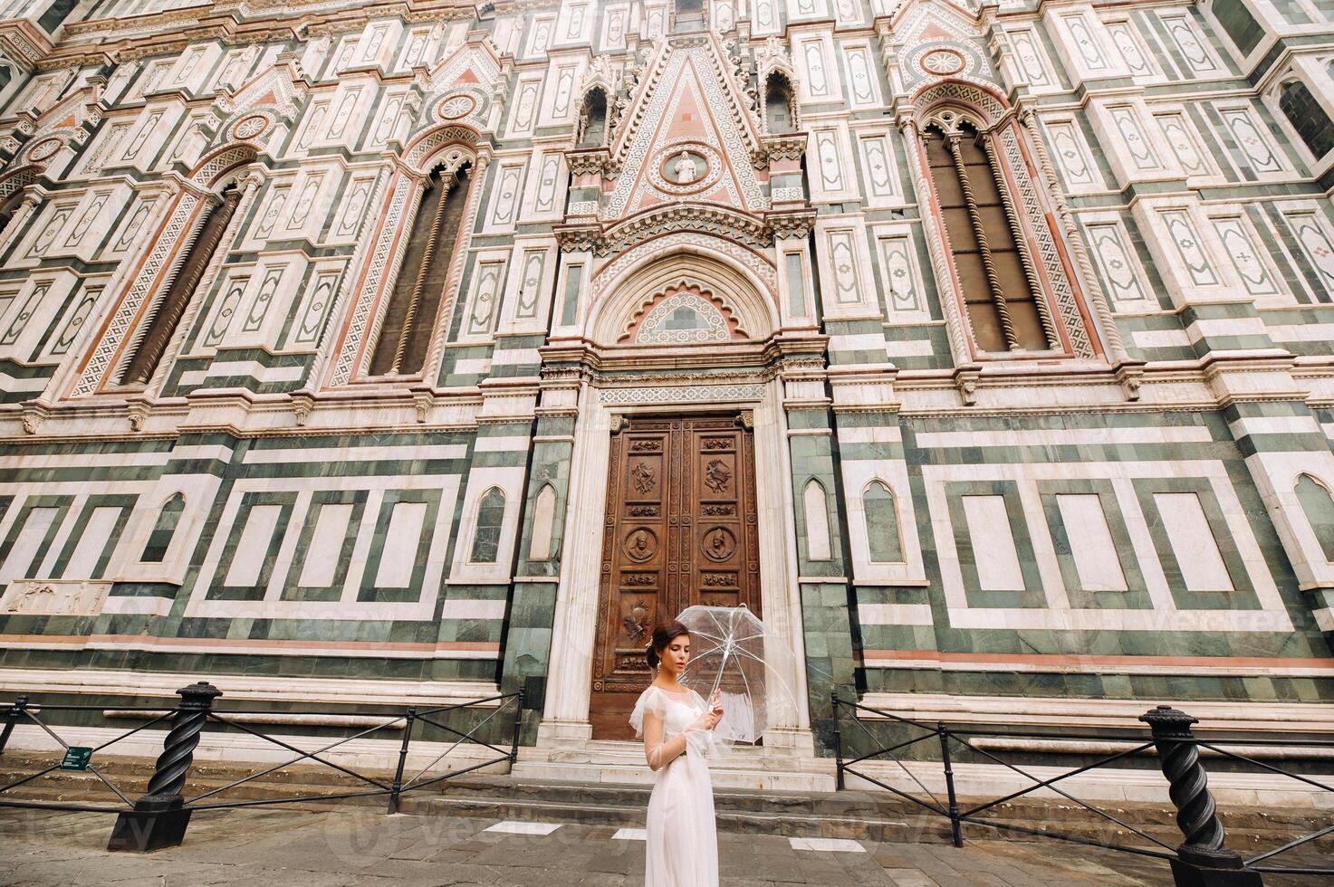 un' bellissimo elegante sposa con un ombrello passeggiate attraverso il vecchio città di firenze.modello con ombrelli nel italia.toscana. foto