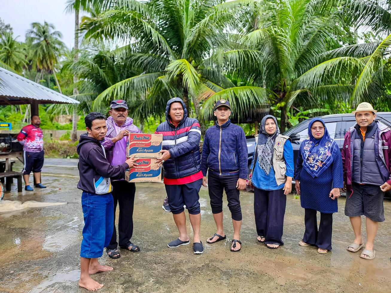 pariama, Indonesia - marzo 8, 2024. Sig. regionale segretario di pariama città mani al di sopra di cibo aiuto per alluvione vittime nel nord pariama quartiere foto