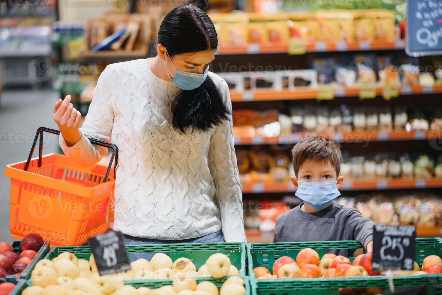 madre e figlio siamo shopping a il drogheria negozio. essi indossare maschere durante quarantena. coronavirus pandemia .coved-19 veloce. il epidemico di il virus. foto