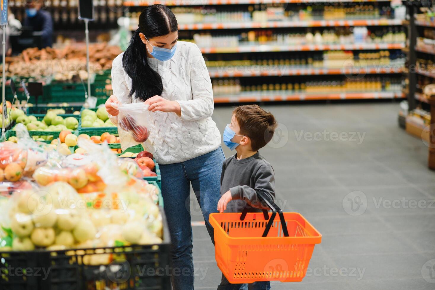 madre e figlio siamo shopping a il drogheria negozio. essi indossare maschere durante quarantena. coronavirus pandemia .coved-19 veloce. il epidemico di il virus. foto