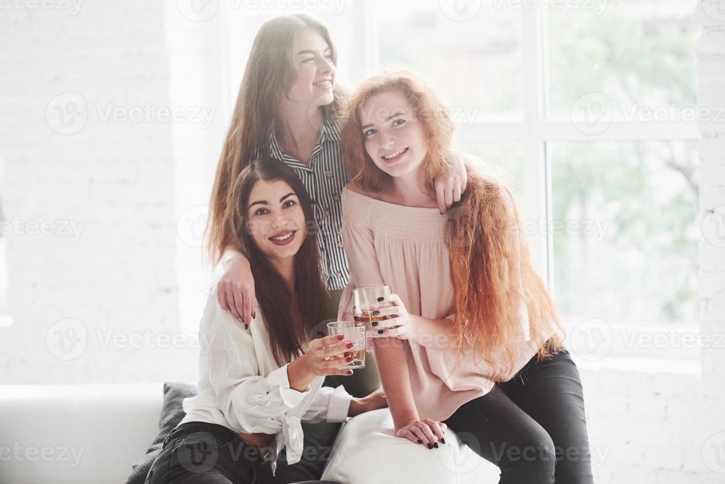 foto di tre ragazze al coperto che tengono bicchieri da whisky e sorridono