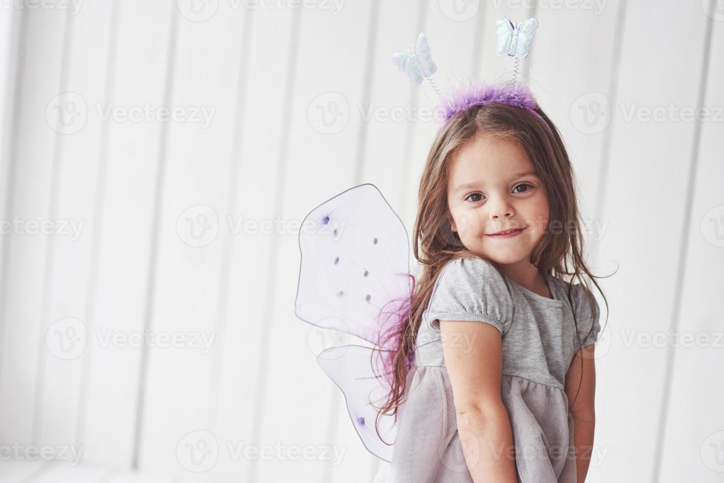 sentirsi calmi e felici. bellissima bambina con costume da fata che si diverte a posare per le foto