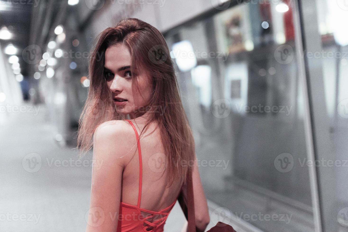 sguardo da vicino. bella ragazza che cammina vicino all'edificio e si gira. foto in movimento