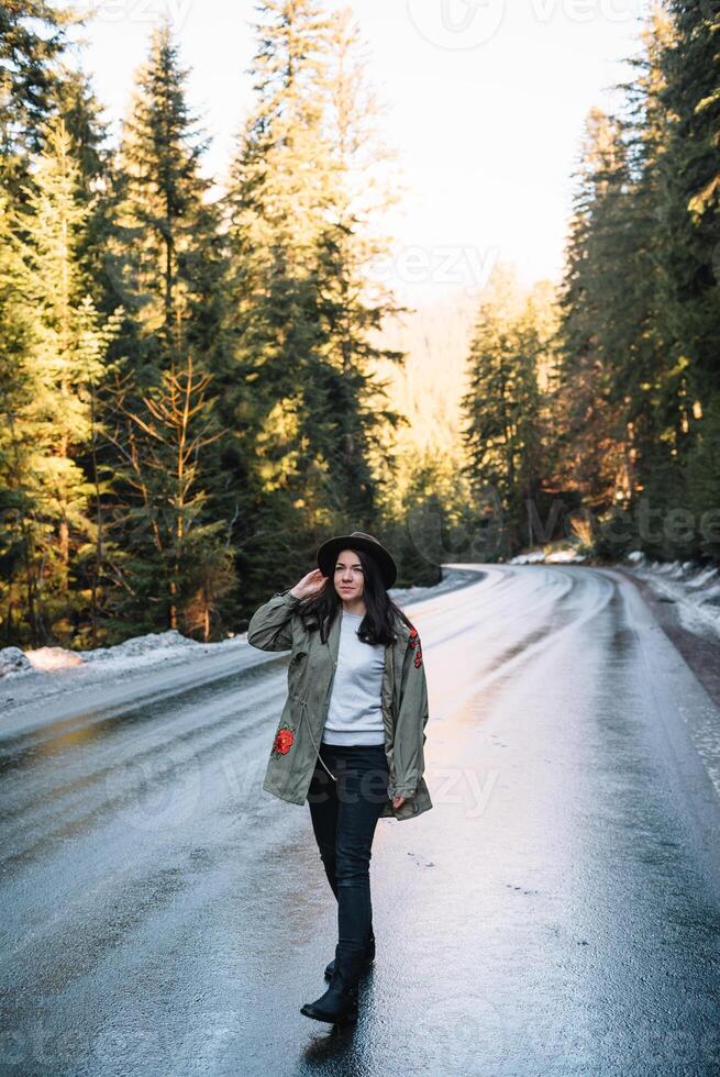 contento ragazza con cappello nel foresta a montagna strada sfondo, rilassare tempo su vacanza concetto viaggio ,colore di Vintage ▾ tono e morbido messa a fuoco foto