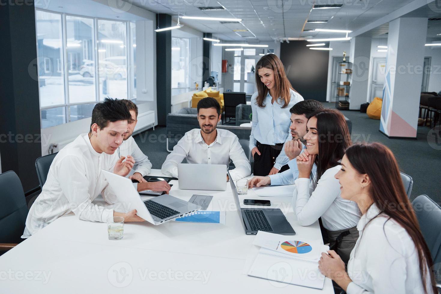 mostrando buoni risultati. un gruppo di giovani liberi professionisti in ufficio conversano e sorridono foto